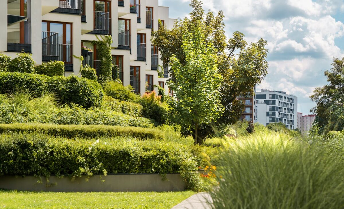 about-03 Elegant modern residential complex with lush gardens and urban landscape views.