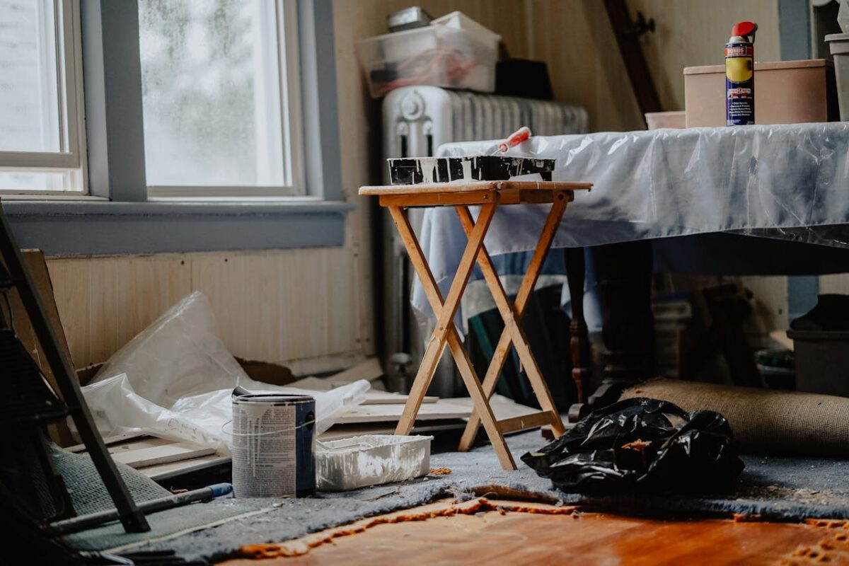 about-04 Interior view of a home renovation with paint supplies on a wooden table.